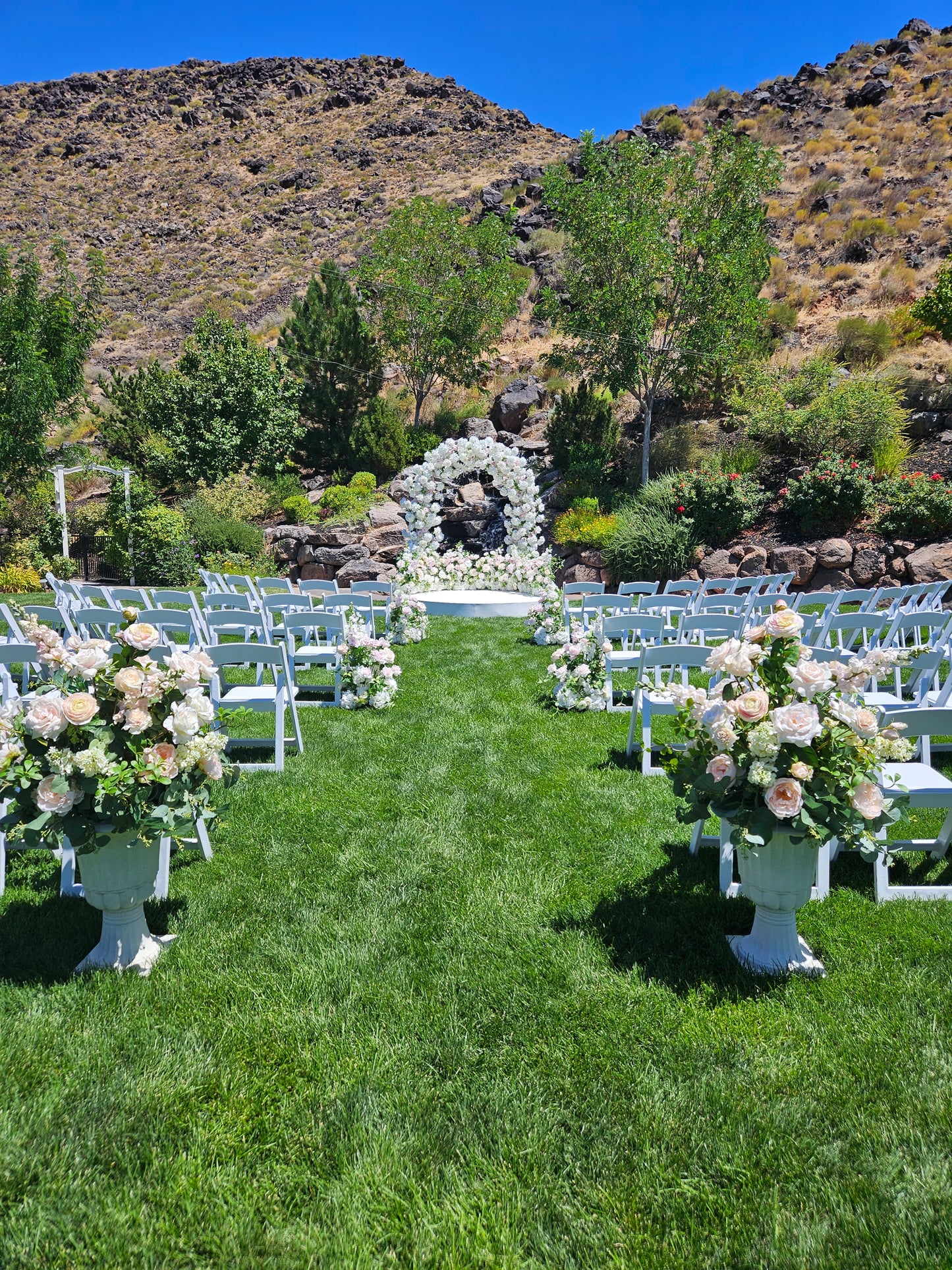 Luxury wedding floral arrangements on a grassy area with mountains in the background