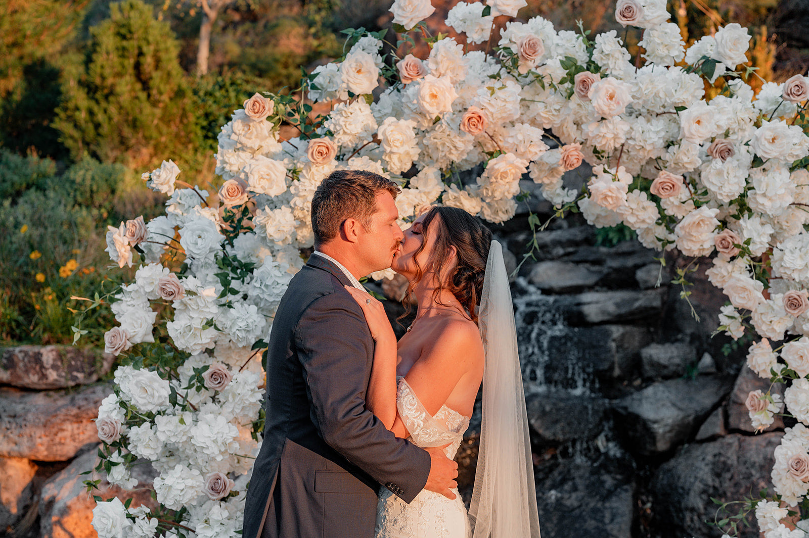 Wedding Picture of Bride and Groom at Alter under white flower circle arch