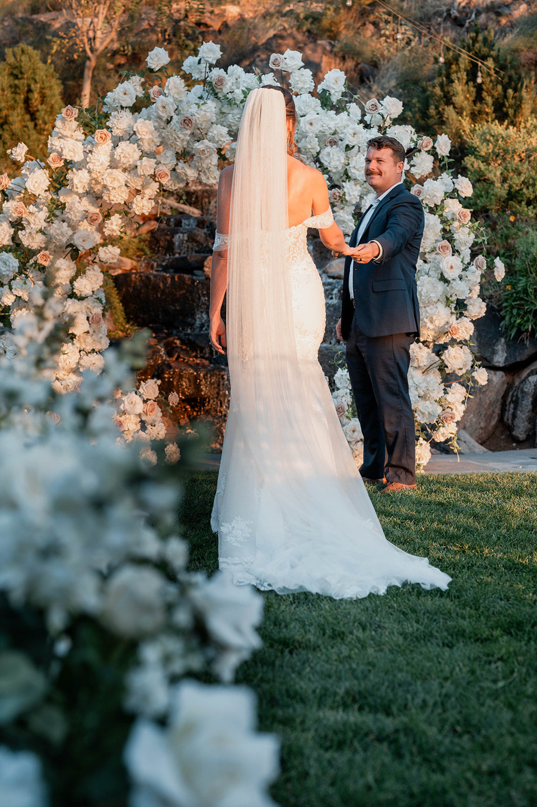 White flower circle arch with bride and groom at alter with fresh aisle flowers in white