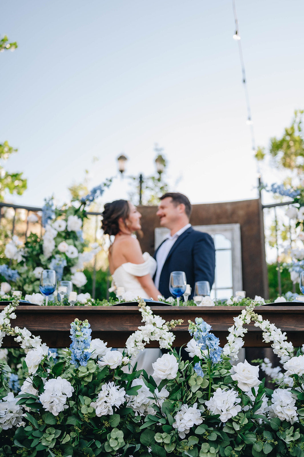 Picture of bride and groom with beautiful flowers and blue sky above